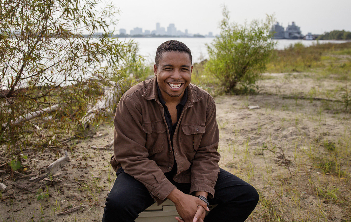 Happy Johnson sitting on a riverbank